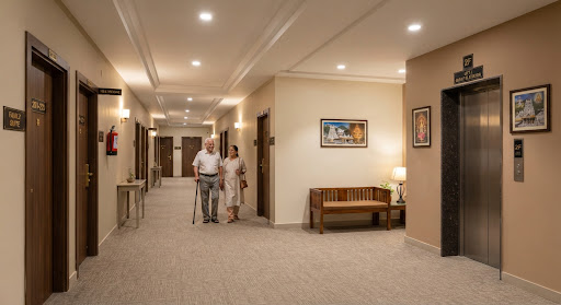 Guest corridor at Nandakam Rest House with clean tiled flooring and soft lighting