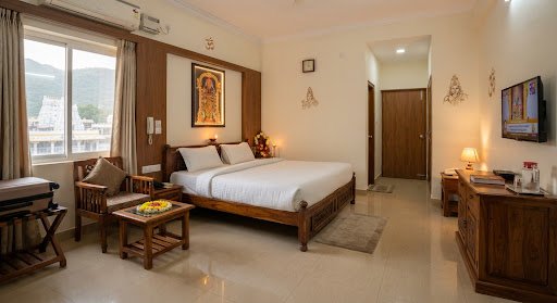 Four-bed family room with tidy beds and spacious tiled flooring at Nandakam Rest House